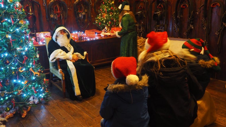 Father Christmas meets 3 children with his elf in the harness room in the old stables